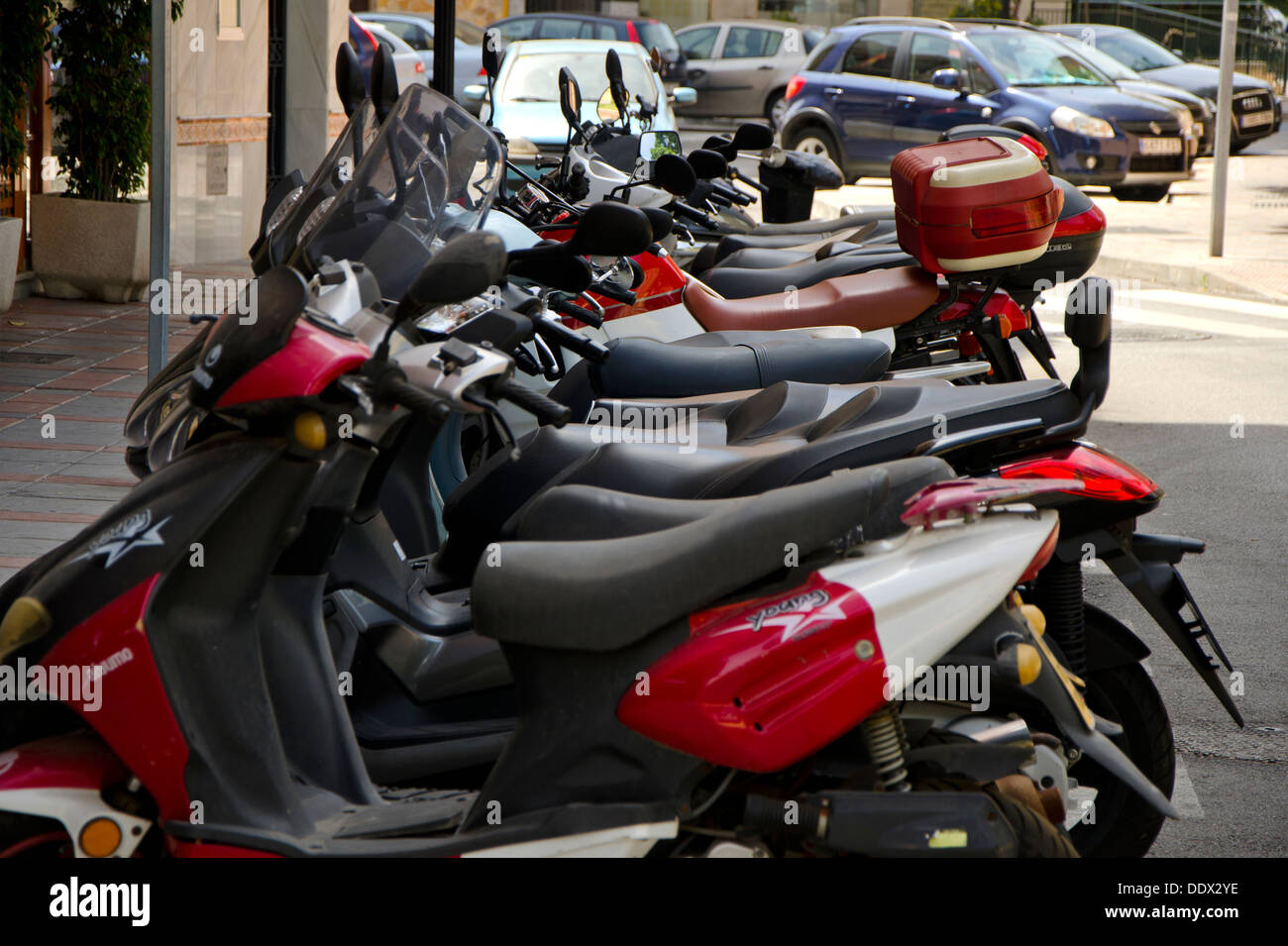 Zeile der Roller in einem spanischen Dorf auf einem Motorrad Parkplatz geparkt Stockfoto