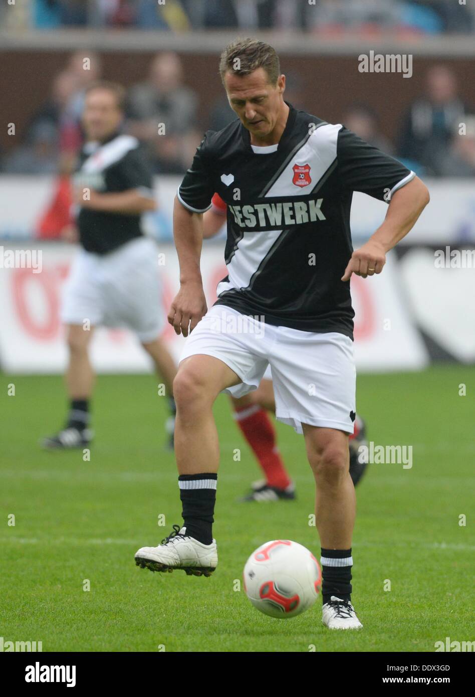 Ehemalige Formel-1-Fahrer Michael Schumacher spielt den Ball während der Tag der Legenden 2013 Fußballspiel im Millerntor-Stadion in Hamburg, Deutschland, 8. September 2013. Der neunten "Tag der Legenden", in dem ehemaligen Profi-Fußballer, gegeneinander profitiert Jugendprojekte in Hamburg.  Foto: MARCUS BRANDT Stockfoto