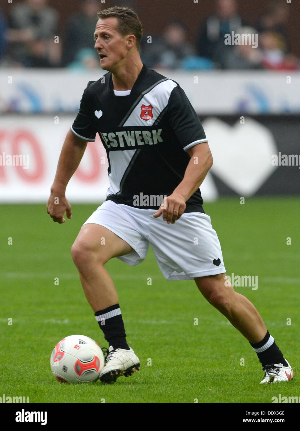 Ehemalige Formel-1-Fahrer Michael Schumacher spielt den Ball während der Tag der Legenden 2013 Fußballspiel im Millerntor-Stadion in Hamburg, Deutschland, 8. September 2013. Der neunten "Tag der Legenden", in dem ehemaligen Profi-Fußballer, gegeneinander profitiert Jugendprojekte in Hamburg.  Foto: MARCUS BRANDT Stockfoto