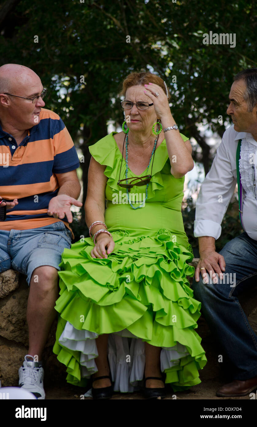 Eine Frau und zwei Männer in einem traditionellen Flamenco Kleid während der jährlichen Messe in Mijas in Südspanien. Costa Del Sol. Stockfoto