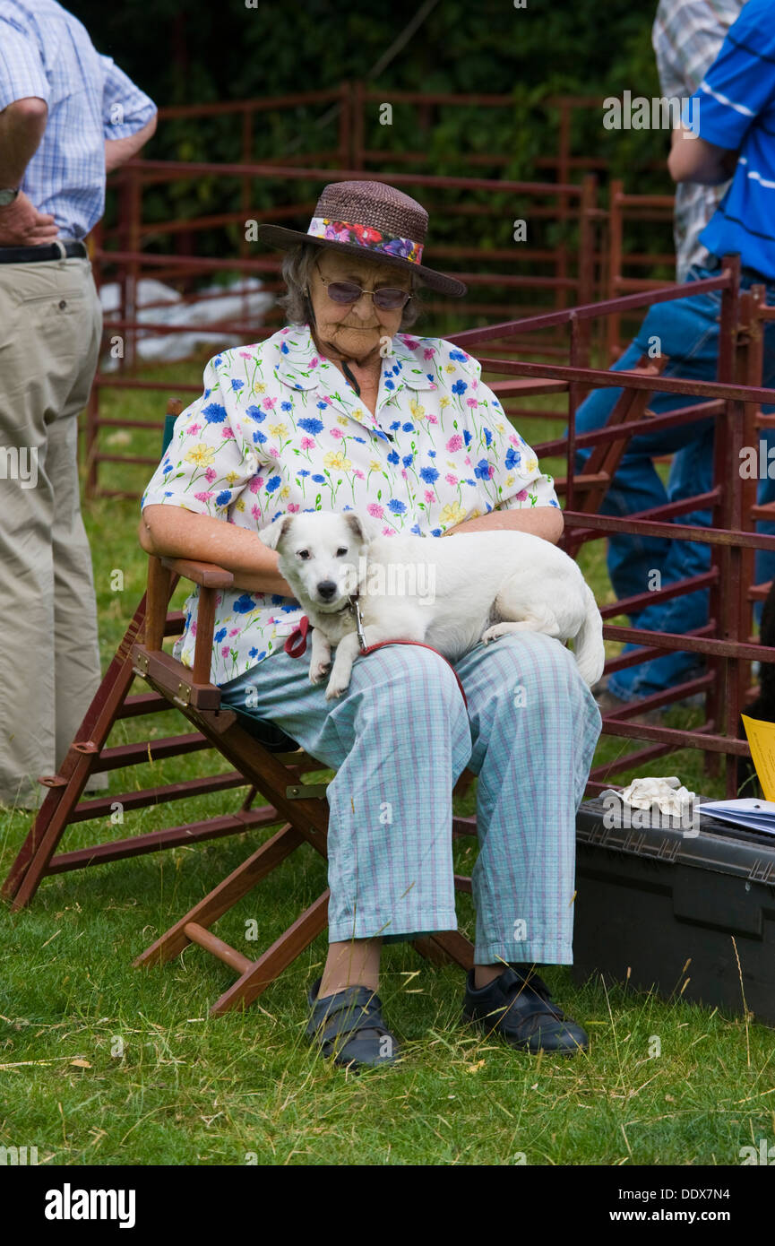 Ältere Dame schlafen sitzend mit Hund auf dem Schoß bei Cwmdu Dorf zeigen Powys Wales UK Stockfoto