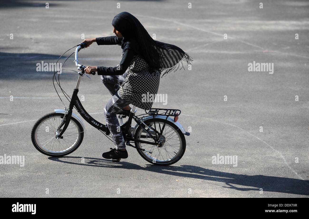 Fartun Jimall aus Somalia Zyklen während einer Übung Radfahren natürlich für Migrantinnen auf einem Schulhof in Bremen-Gröpelingen, Deutschland, 27. August 2013. Radfahren - was viele als einfach, ist ein Problem für rund 1 Million Erwachsene.  Foto: Carmen Jaspersen Stockfoto