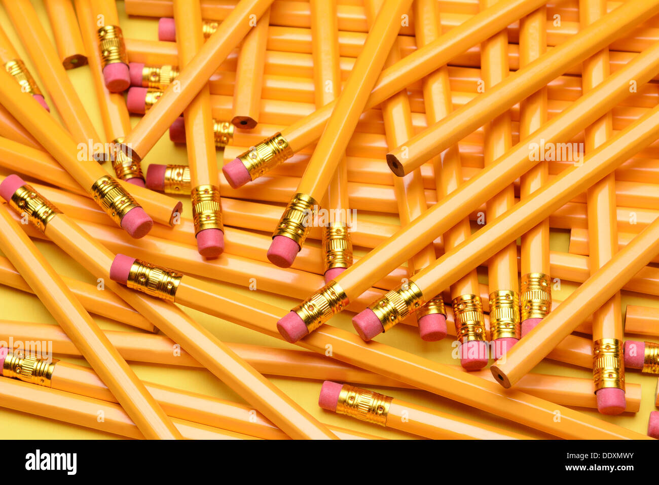 Ein zufälliger Haufen von Bleistiften. Brandneue Bleistifte auf eine gelbe Fläche verstreut. Ideal für zurück zu Schulprojekte. Stockfoto