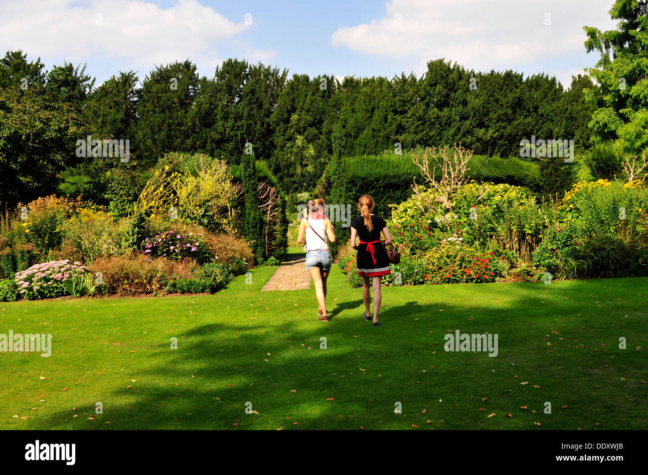 Zwei junge Frauen, die zu Fuß in Fellows Garten, Clare College in Cambridge, UK Stockfoto