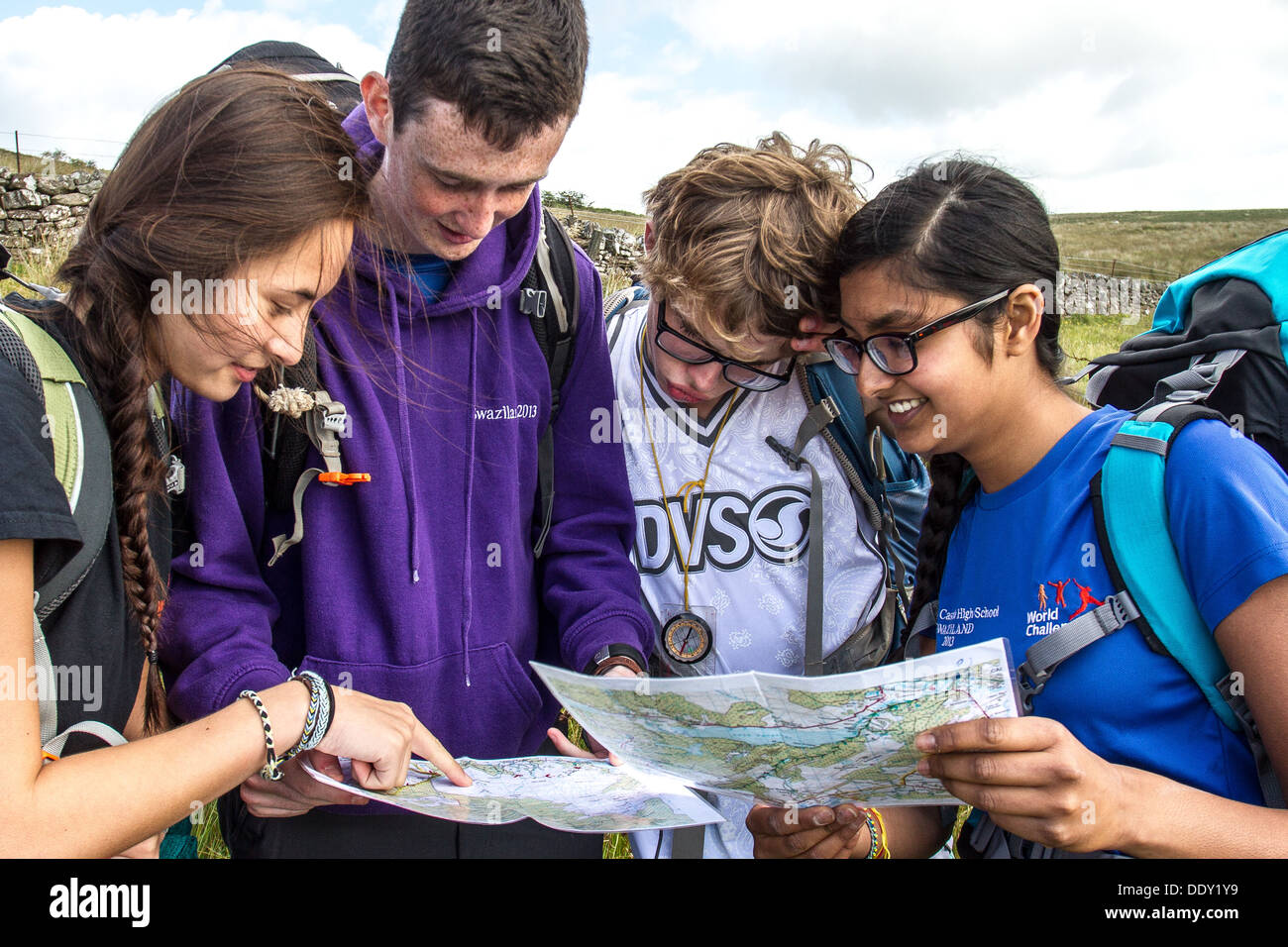 Eine gemischte Gruppe von jungen Menschen eine Karte lesen und Navigieren in der Landschaft Stockfoto
