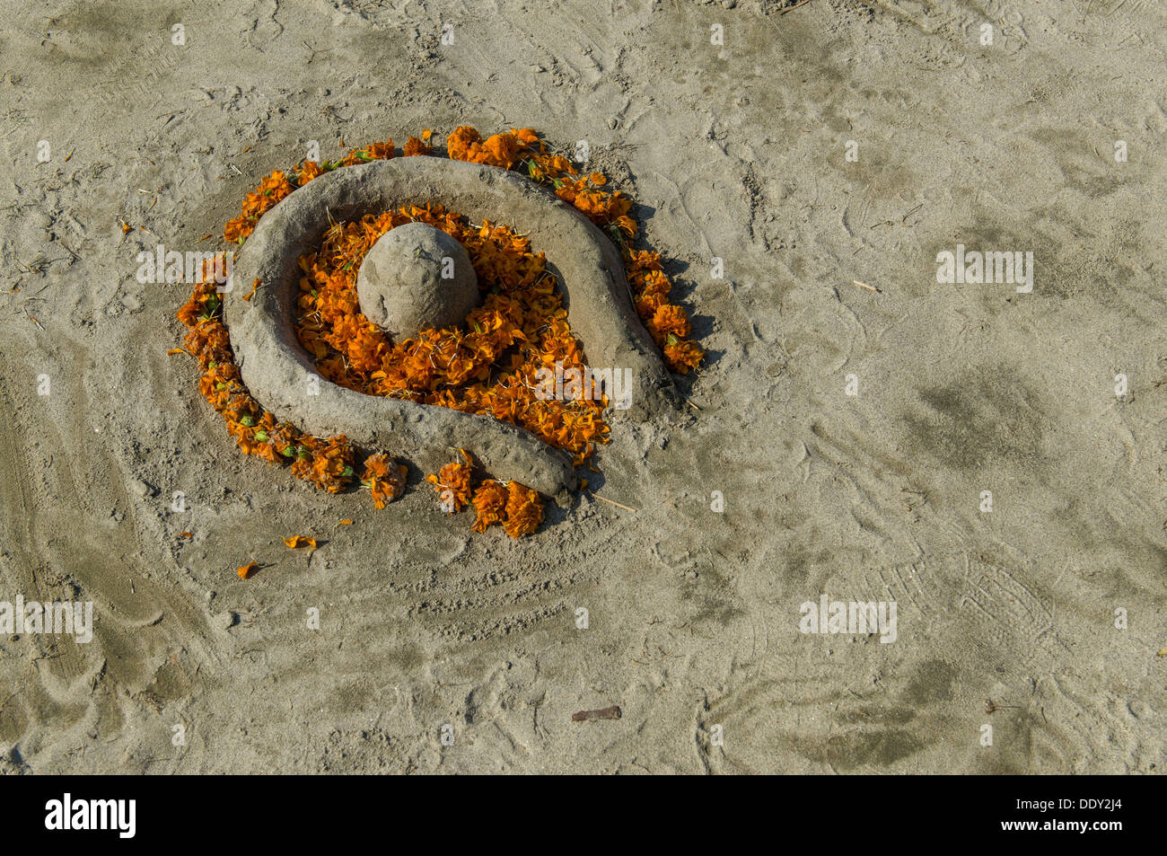 Shiva Lingam aus Sand und Blumen, während Kumbha Mela Stockfoto
