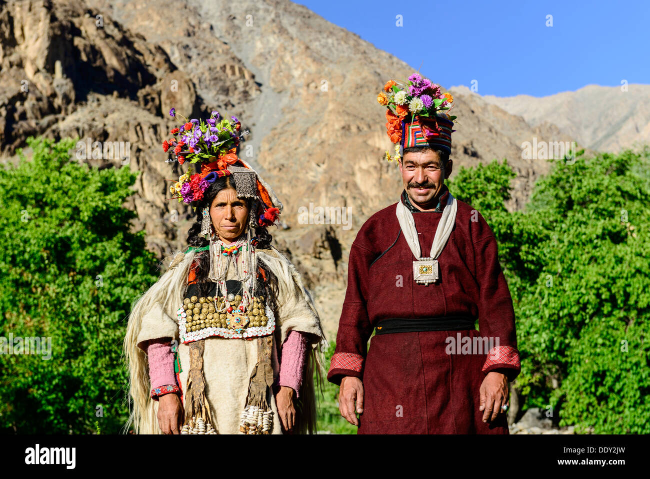 Ein paar des Stammes Brokpa traditionelle Kleider mit Blumen Kopfschmuck tragen Stockfoto
