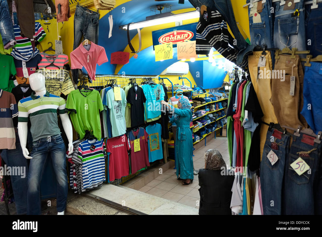 Eine palästinensische Frau durchsucht Waren in einem Bekleidungsgeschäft in Beit Habad auch Khan az Zait Straße im muslimischen Viertel der Altstadt Ost Jerusalem Israel Stockfoto