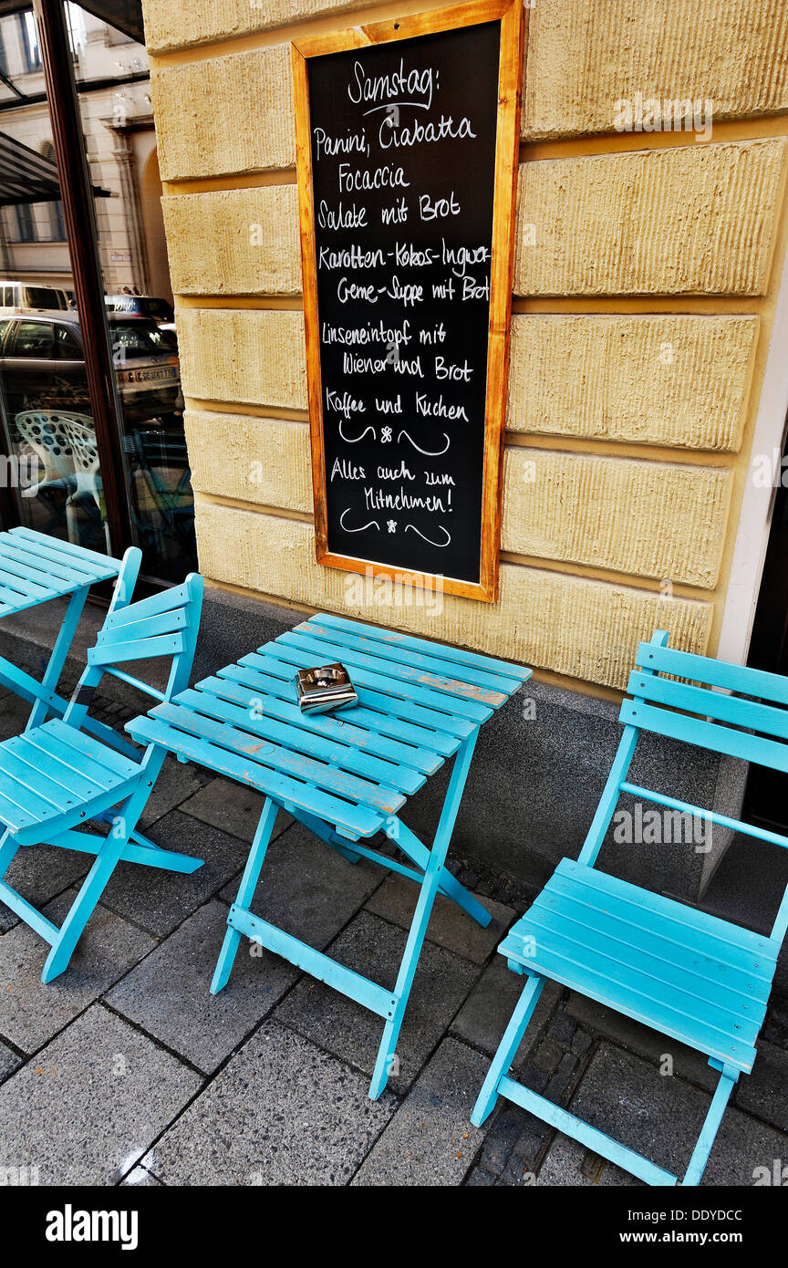 Straßencafé mit einem Menü Board und blaue Tische und Stühle, München, Bayern Stockfoto
