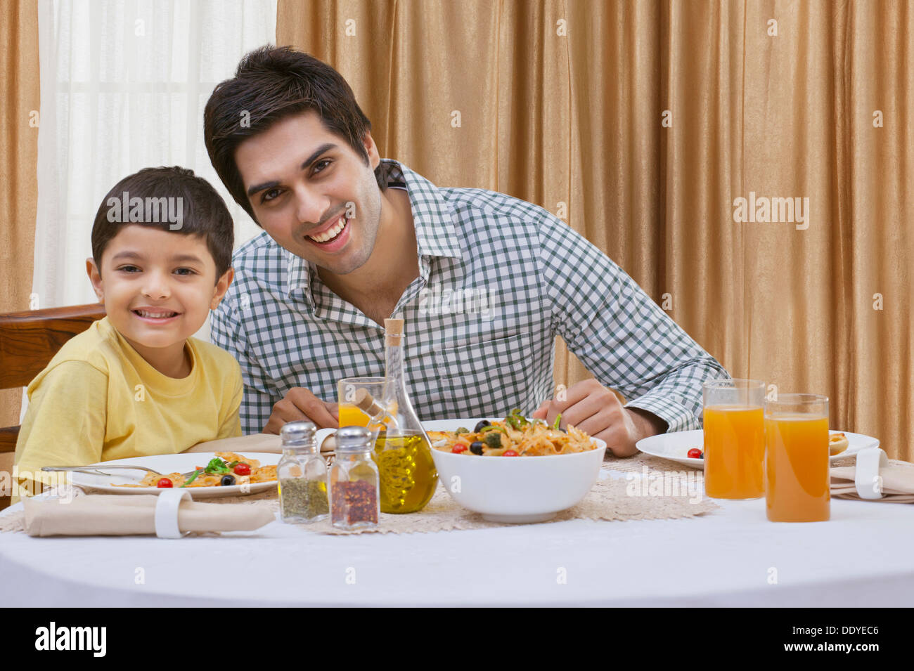 Porträt eines glücklichen Vater und Sohn mit Pizza am Tisch Stockfoto