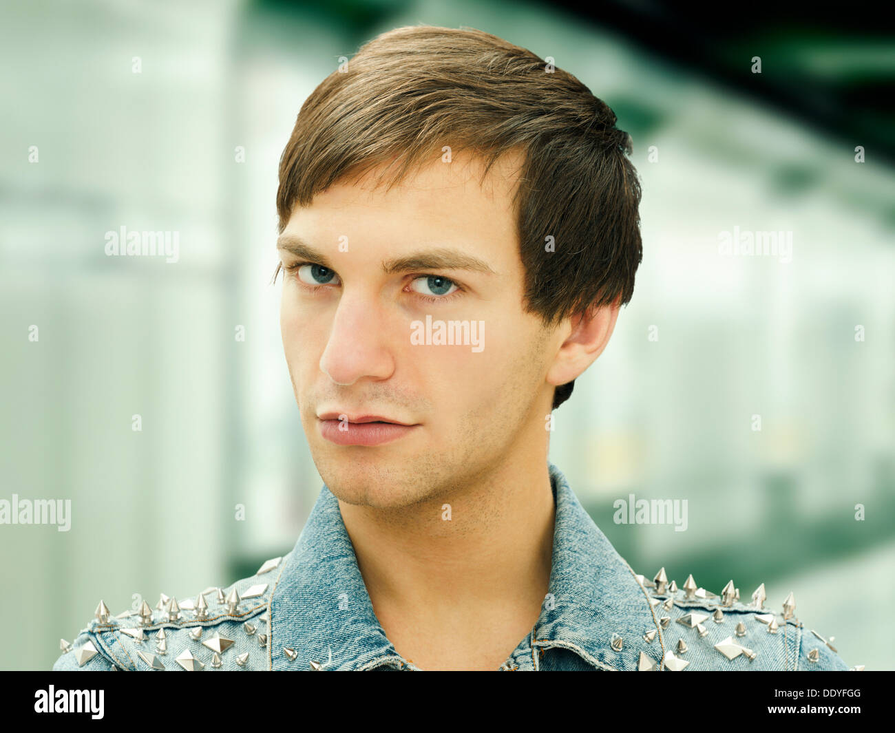 Junger Mann mit einem ernsten Gesicht tragen Nieten Jeansjacke, Porträt Stockfoto