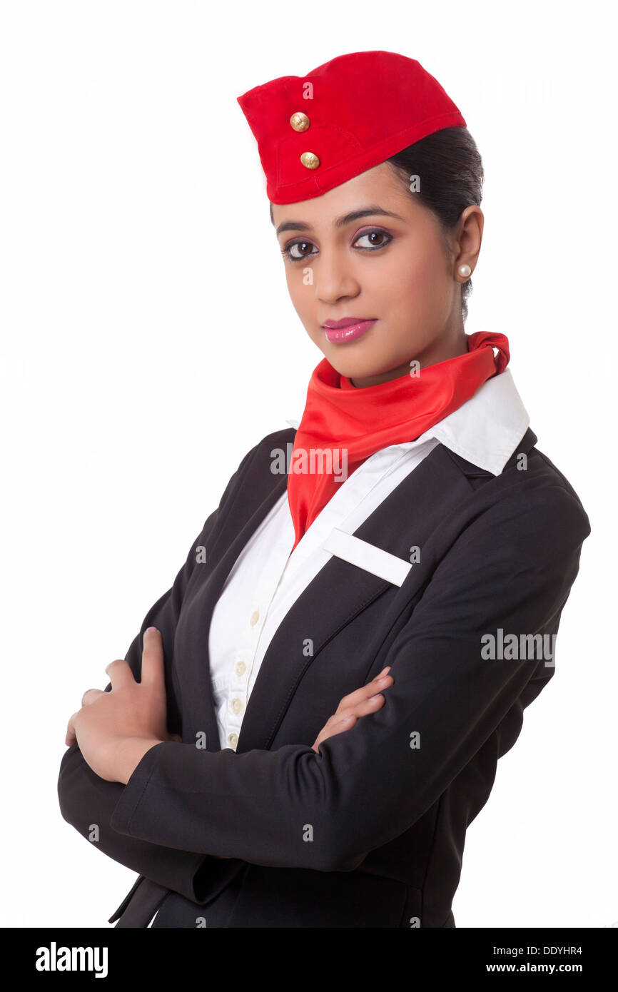 Porträt der Stewardess mit verschränkten Armen vor weißem Hintergrund stehen Stockfoto