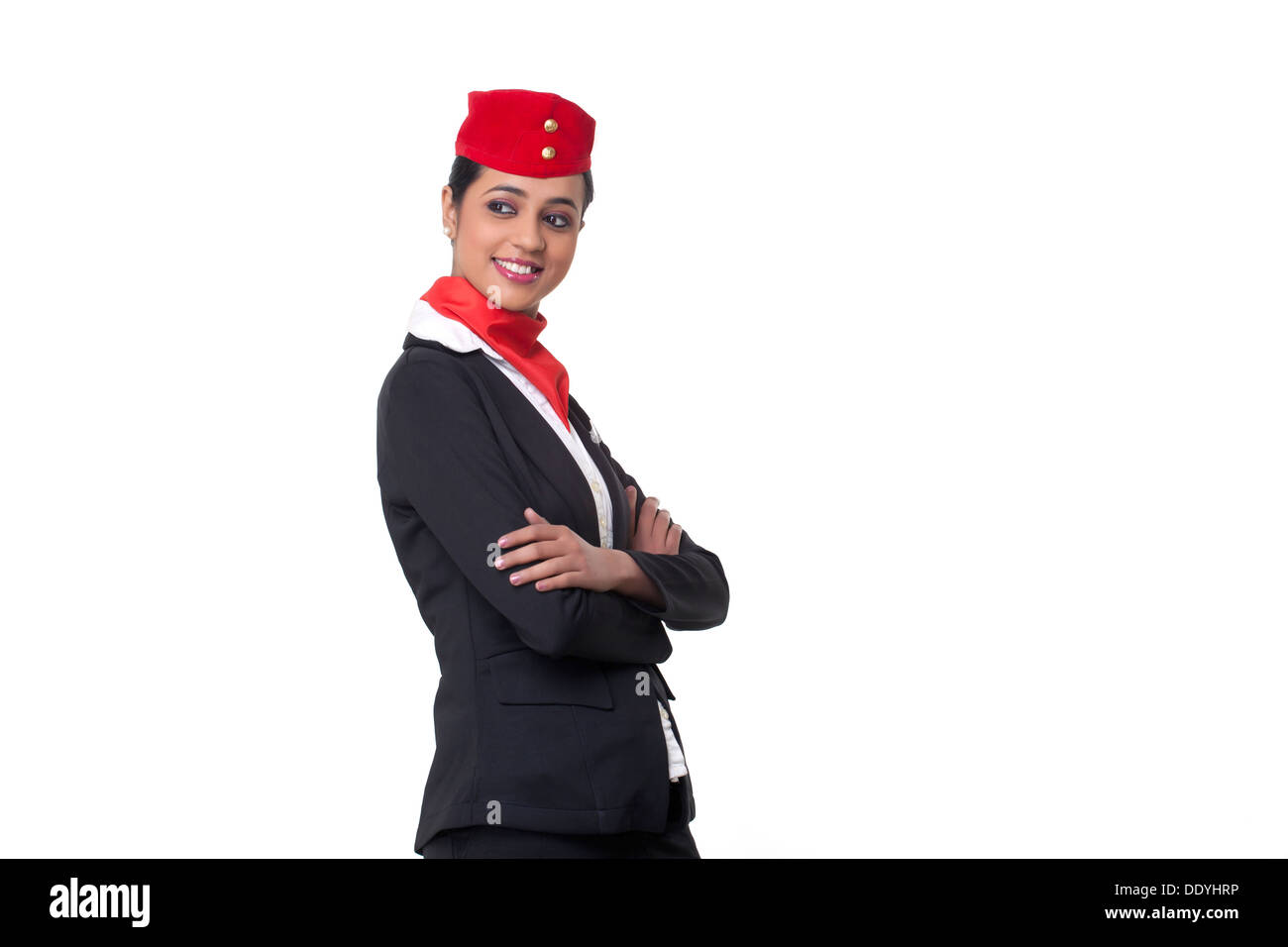 Junge Stewardess mit verschränkten Armen vor weißem Hintergrund wegschauen Stockfoto