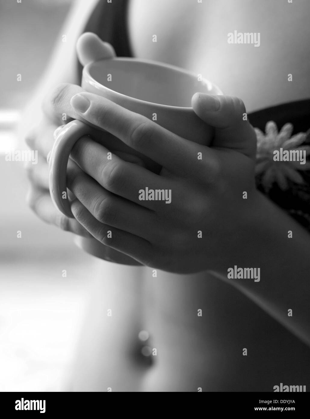 Frau hält eine Kaffeetasse in ihren Händen Stockfoto