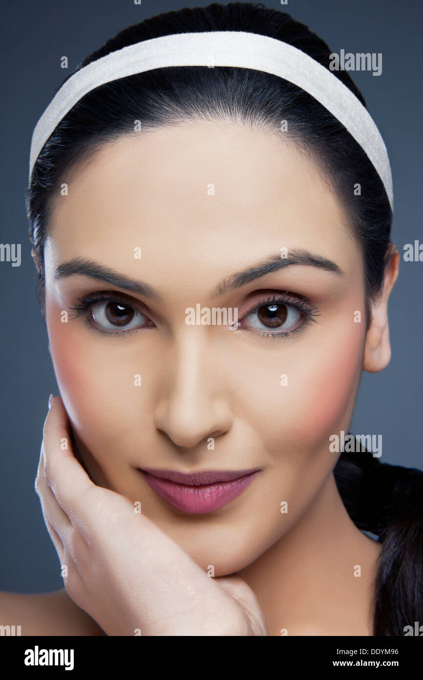 Kopf geschossen Porträt einer schönen jungen Frau berühren ihr Gesicht über farbigen Hintergrund Stockfoto