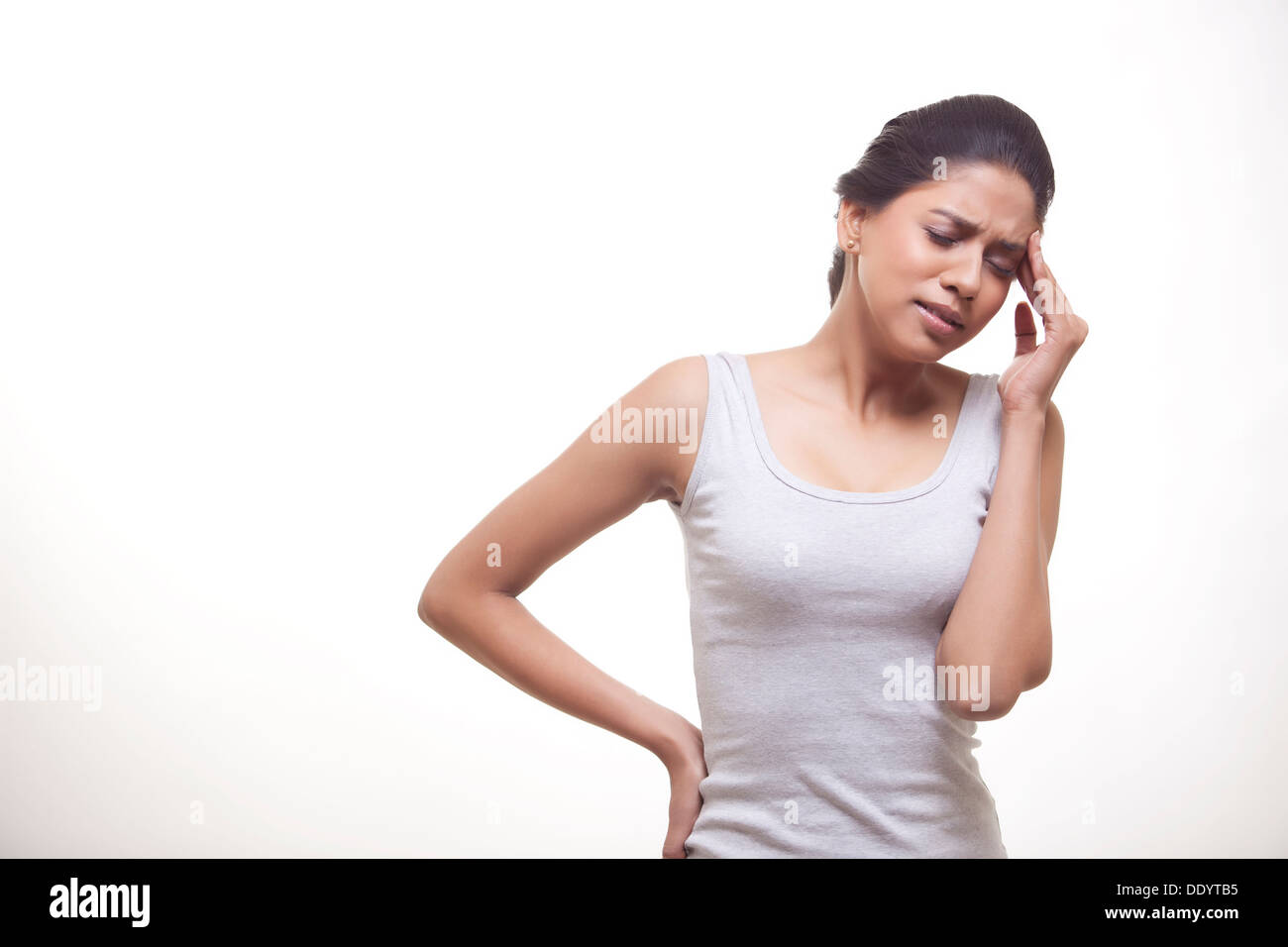 Junge Frau, die leiden unter Kopfschmerzen vor weißem Hintergrund Stockfoto