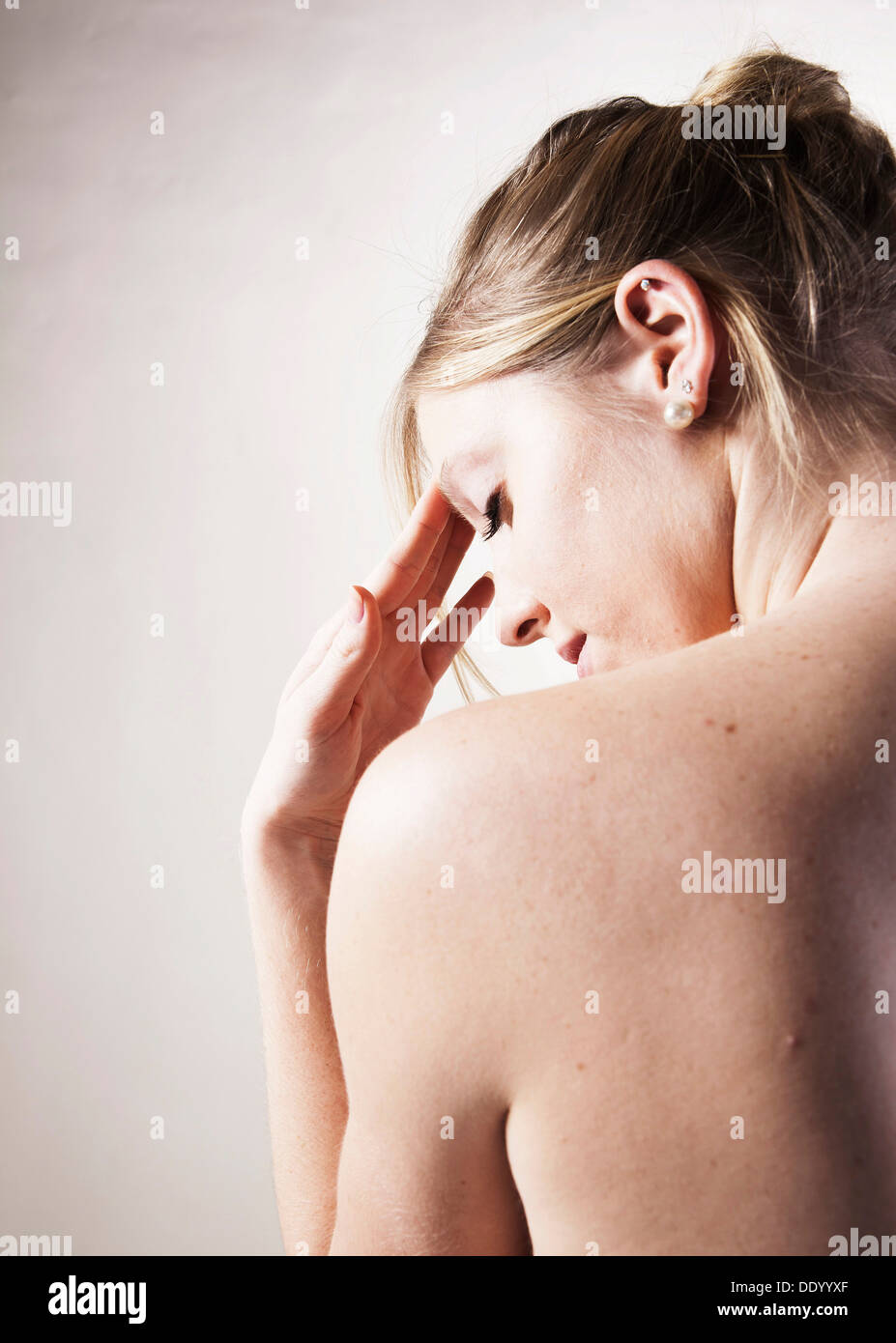 Junge Frau mit Kopfschmerzen, nackten Rücken Stockfoto