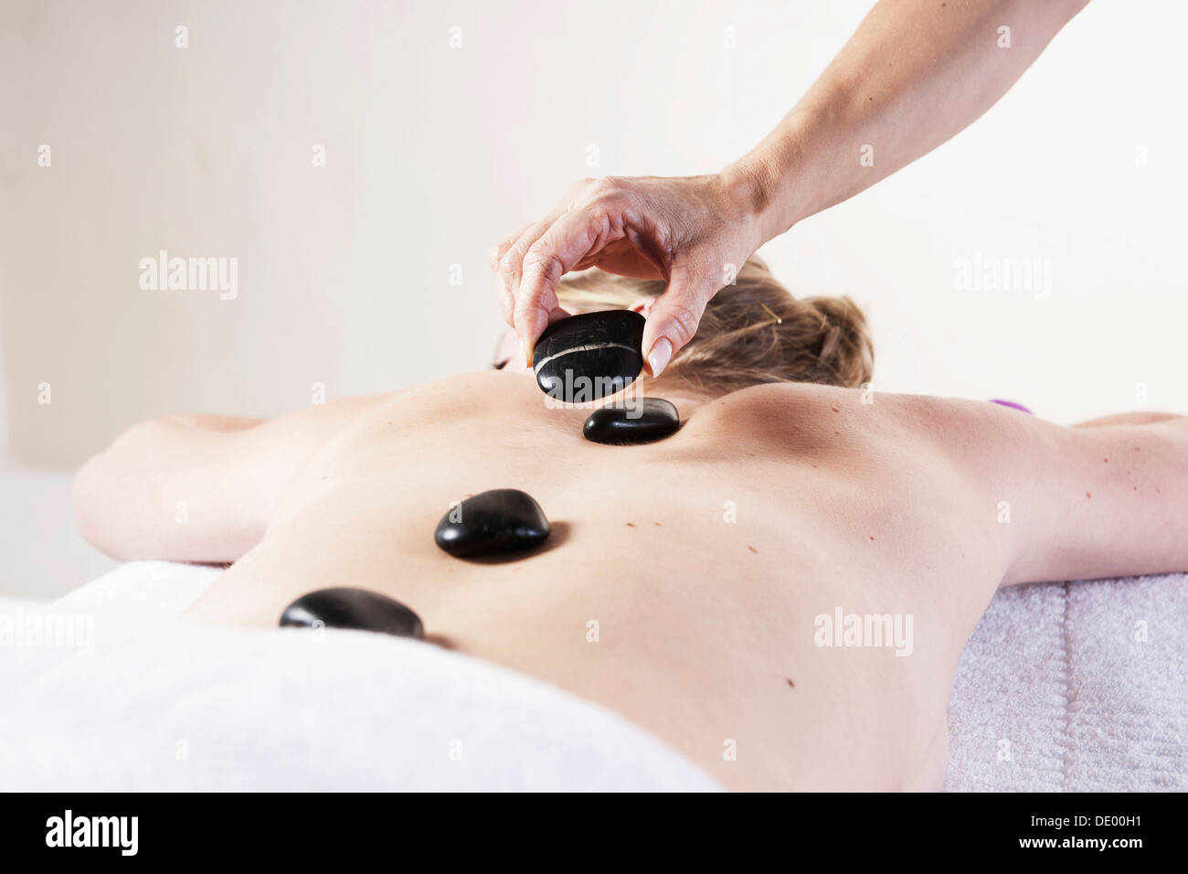 Junge Frau, die Behandlung mit heißen Steinen, hot-Stone-massage Stockfoto
