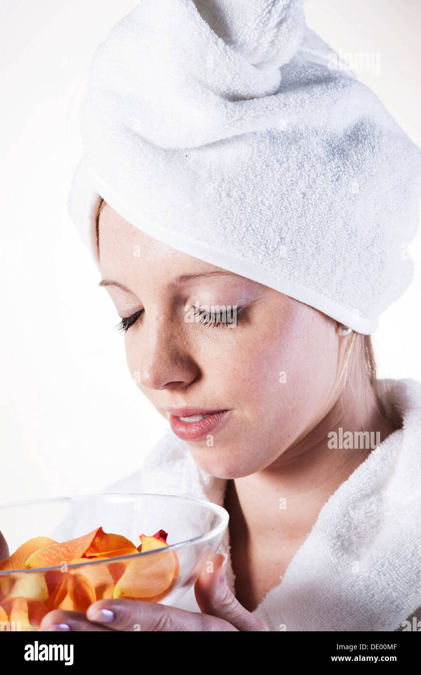 Junge Frau genießen Sie den Duft von Rosenblüten Stockfoto