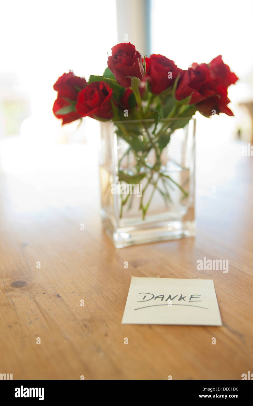 Rote Rosen in Vase mit dem Vermerk "Danke", Deutsch für "Danke" Stockfoto