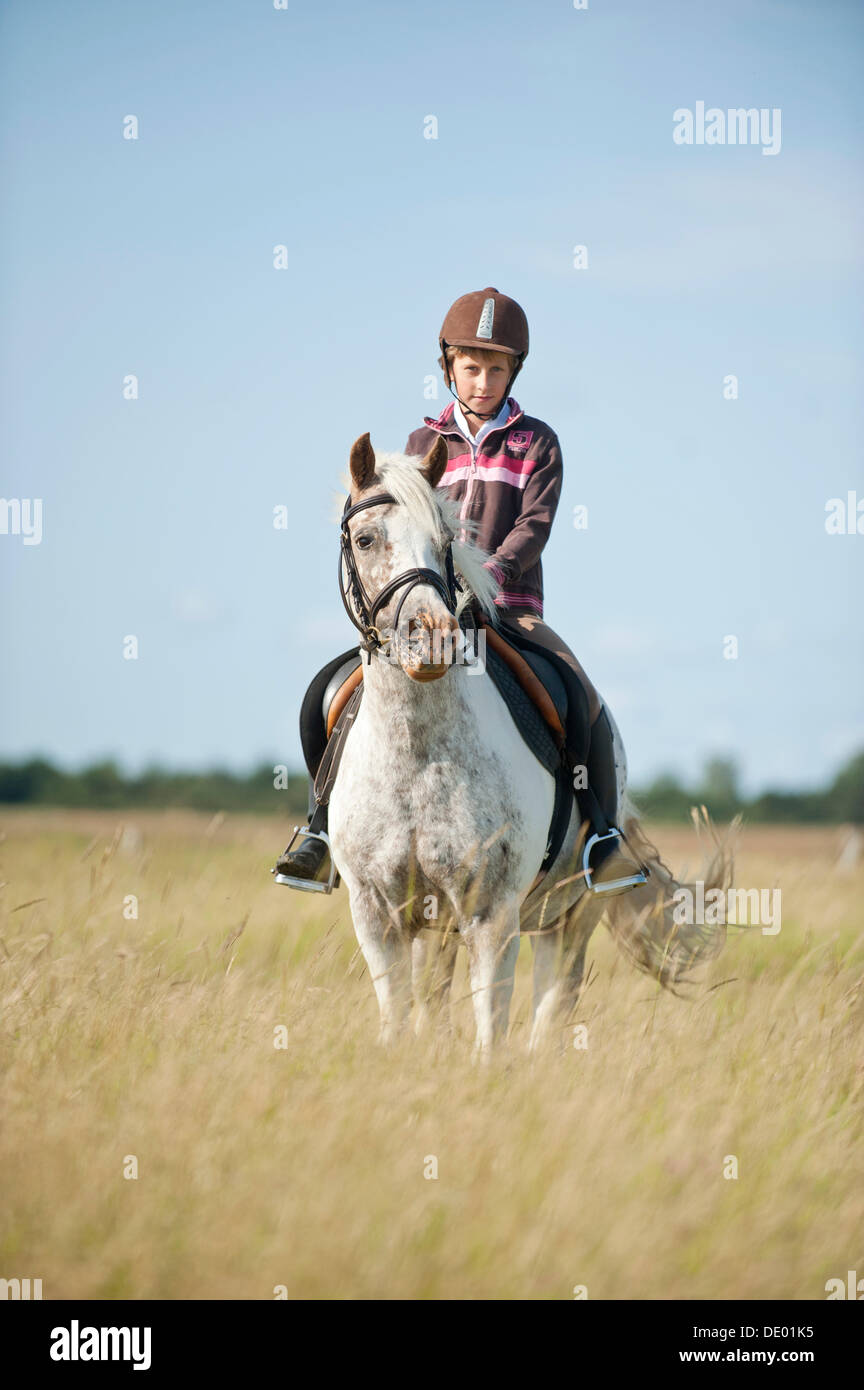 Mädchen Ponyreiten in Dünen Stockfoto