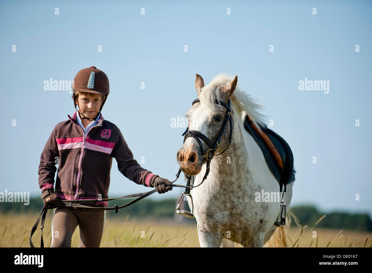Mädchen ein Pony auf die Zügel führt Stockfoto