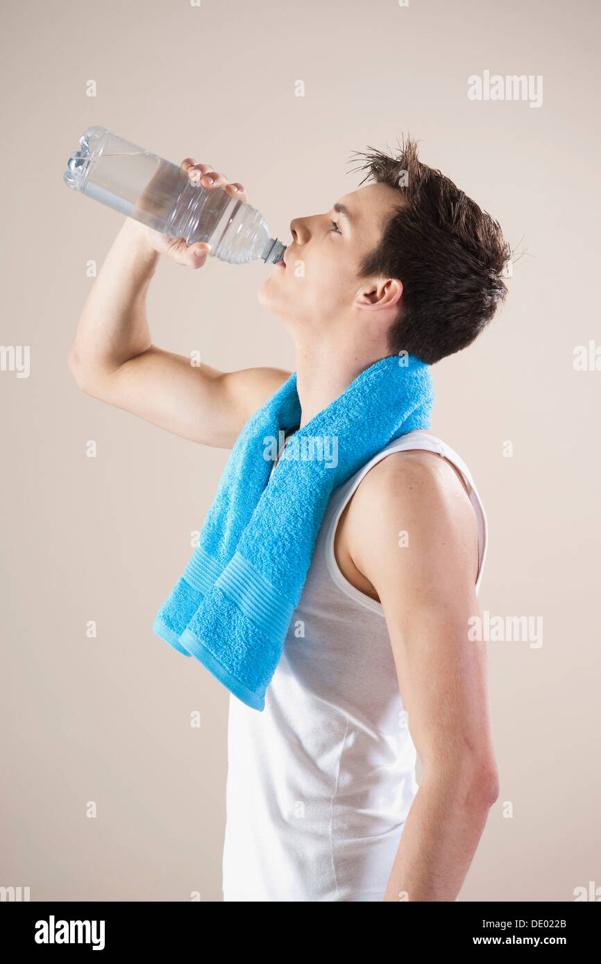 Junger Mann stillt seinen Durst mit einer Flasche Wasser nach dem Sport Stockfoto