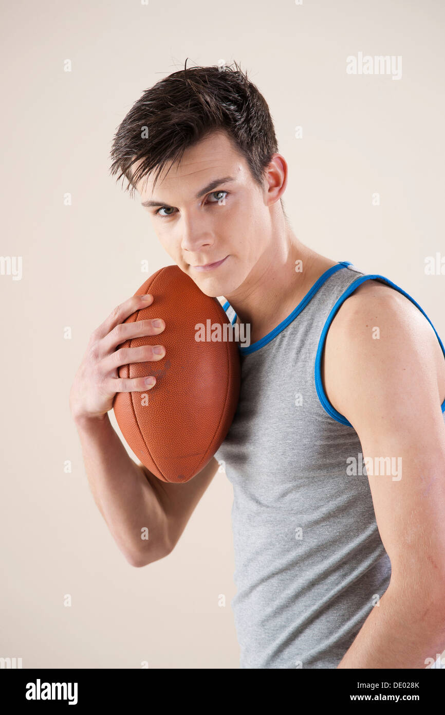 Junger Mann mit einem Fußball in der hand Stockfoto