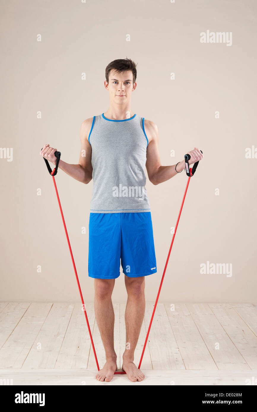 Junge Mann tut, Kräftigung und Dehnung Übungen mit einem Kautschuk-Seil Stockfoto