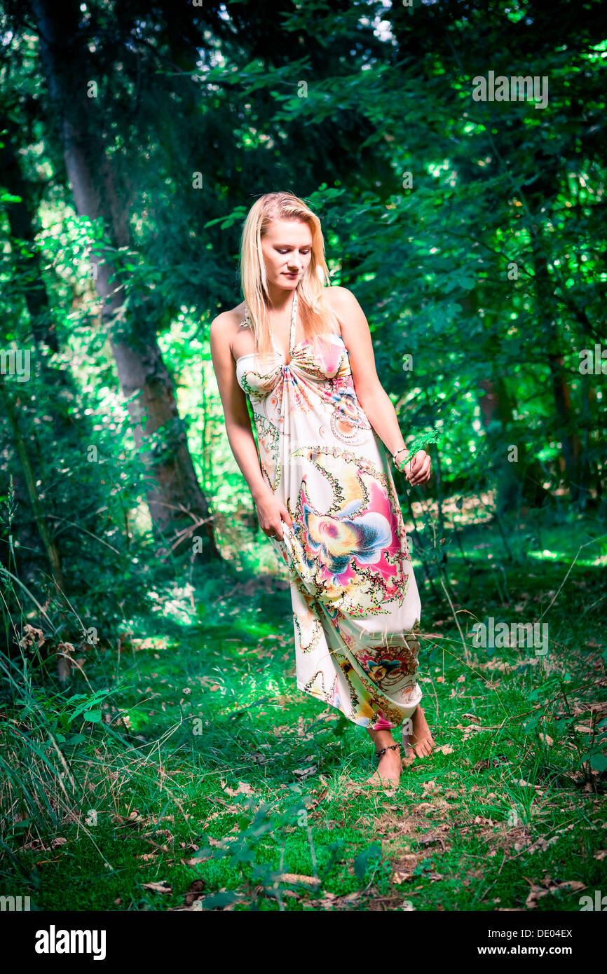 Junge Frau trägt ein Sommerkleid im Wald Stockfoto
