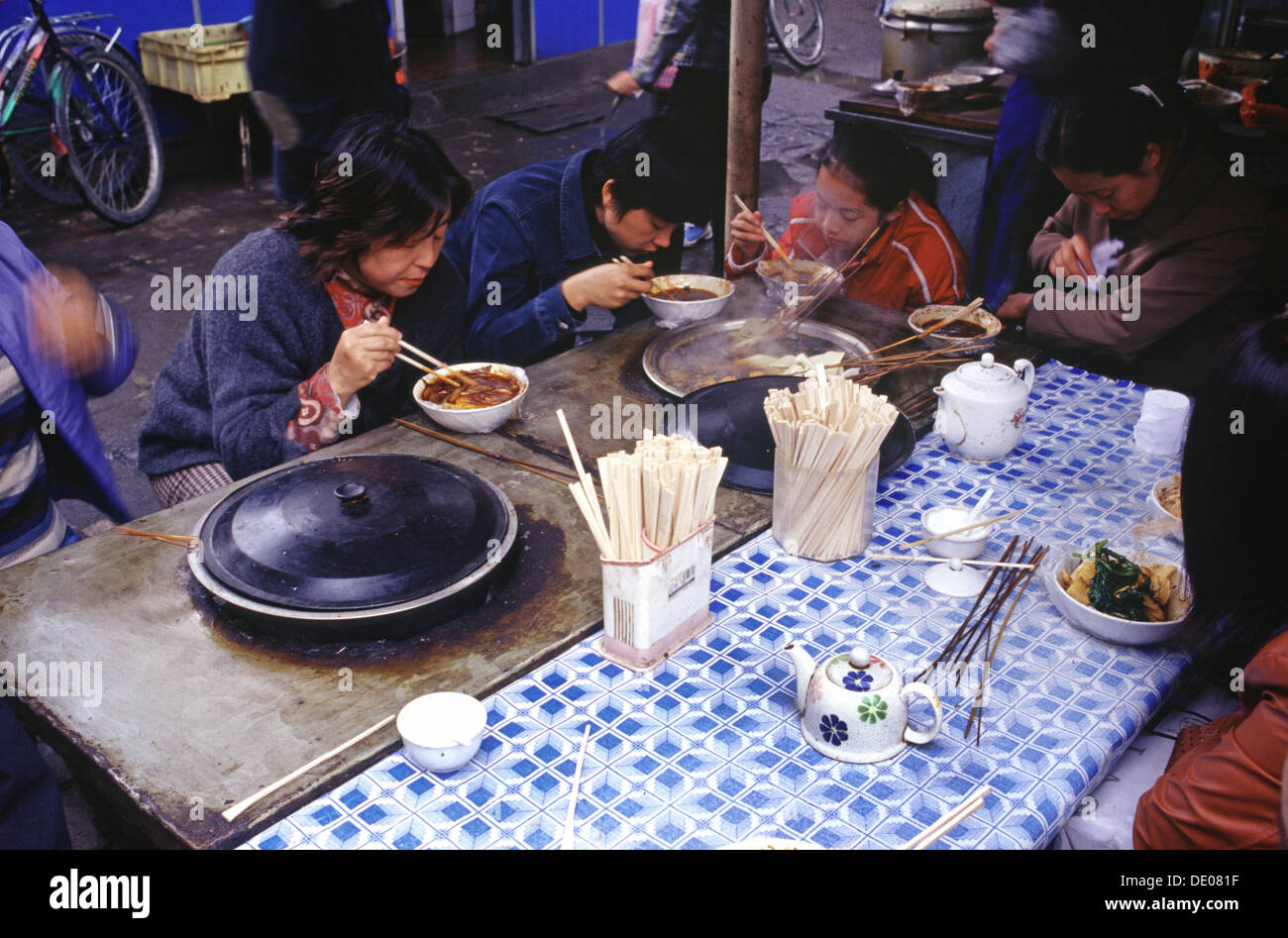 Die Chinesen essen mit Stäbchen in einer Straße Markt in China Stockfoto Die Chinesen essen mit Stäbchen in einer Straße Markt in China Stockfoto
