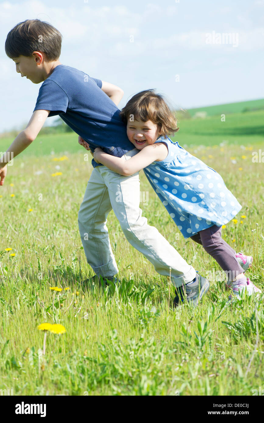 Junge Geschwister zusammen spielen im freien Stockfoto