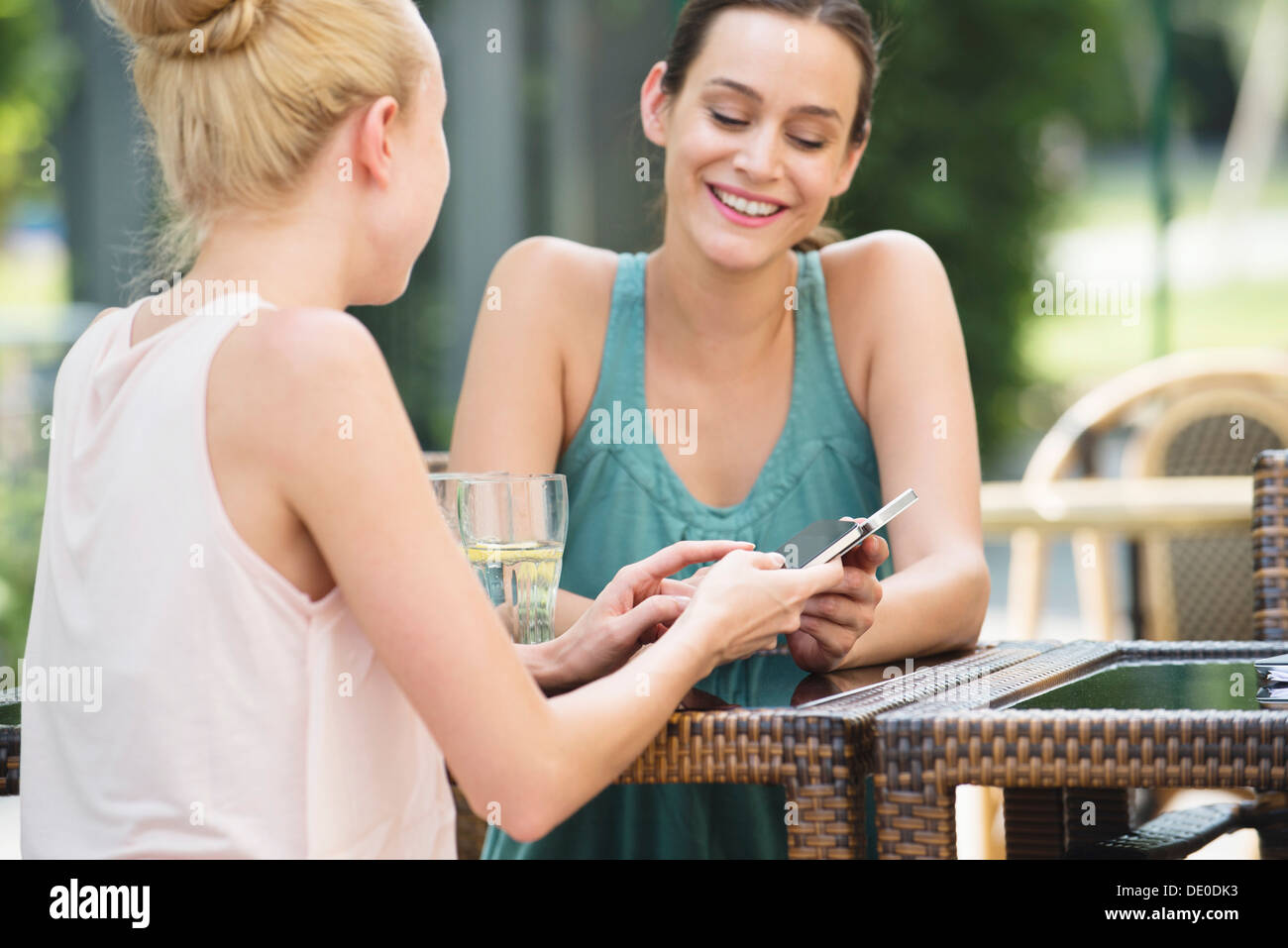Frauen mit Smartphones bei Freiluft-café Stockfoto