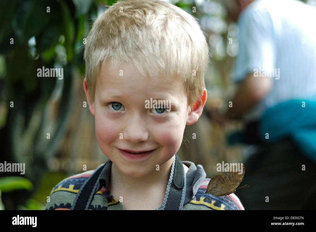 Kleiner Junge, 8 Jahre alt, mit einem Schmetterling auf seiner Schulter