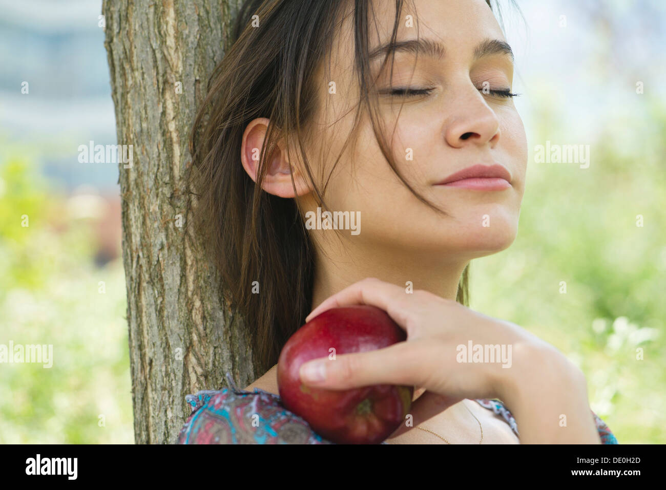 Frau entspannen im Freien mit geschlossenen Augen, mit Apfel Stockfoto