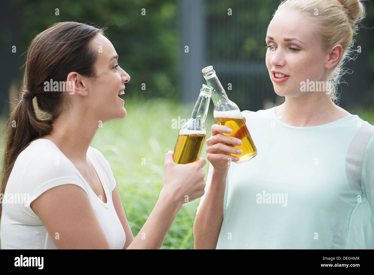Frauen zusammen trinken, klirrende Flaschen Stockfoto