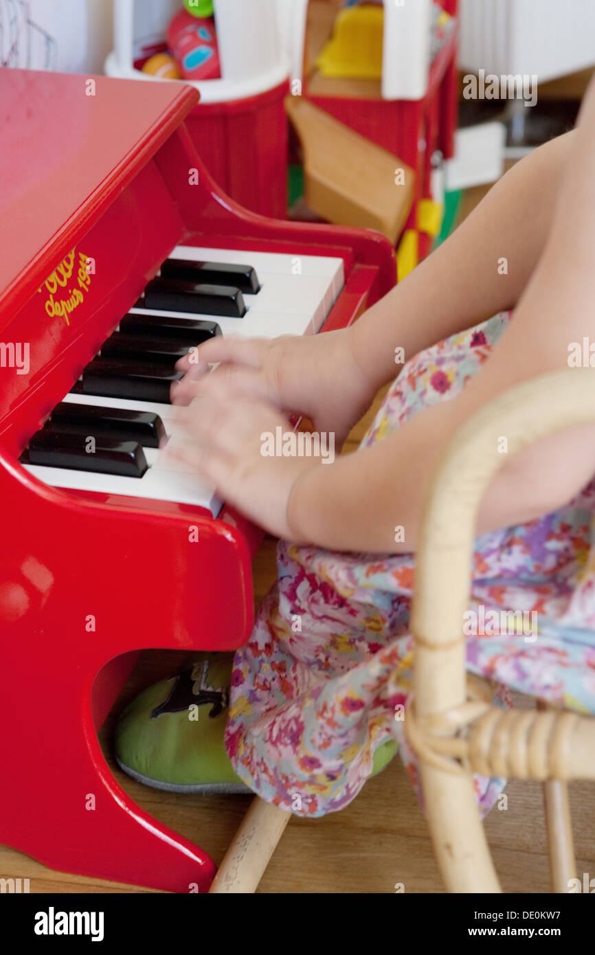 Kleine Mädchen spielen Spielzeug-Klavier, beschnitten Stockfotografie -  Alamy
