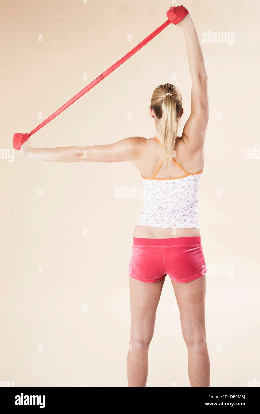 Junge Frau mit einem Theraband Übungen Stockfoto