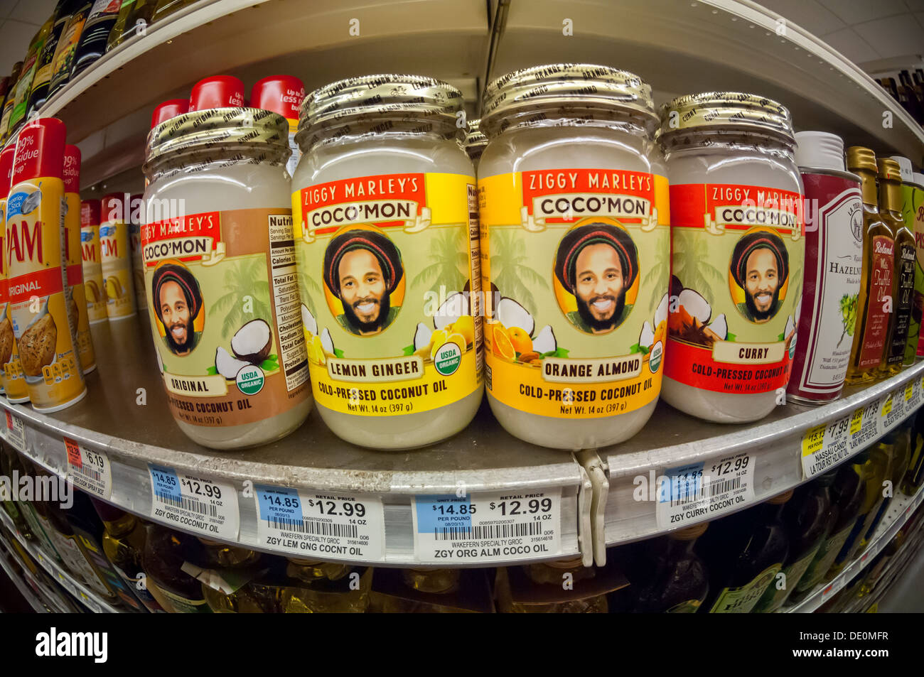 Flaschen von Ziggy Marley Coco'Mon kalt gepresstes Bio-Kokosöl, in einer Vielzahl von Geschmacksrichtungen, sind auf einem Supermarktregal gesehen. Stockfoto