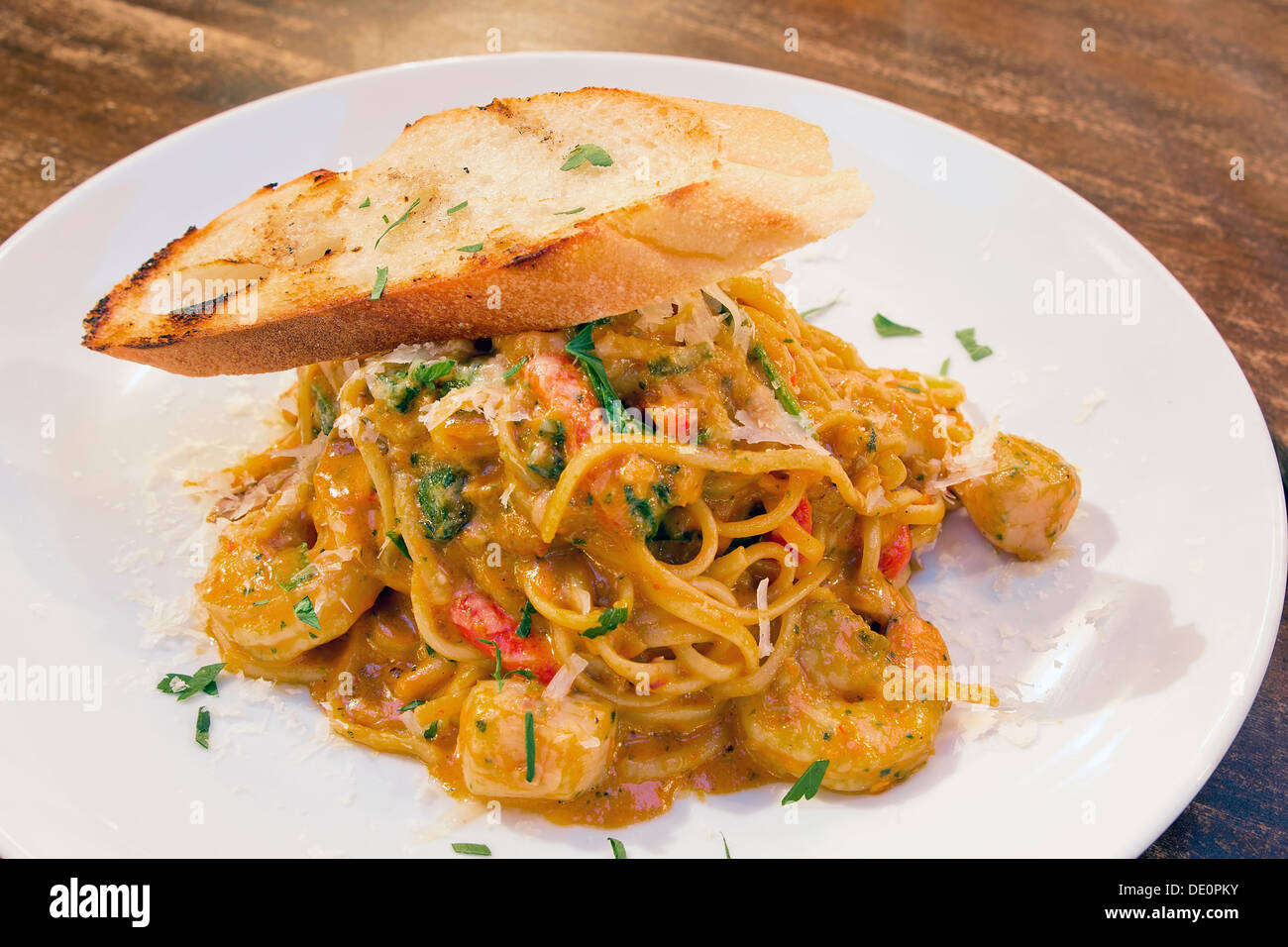 Meeresfrüchte Spaghetti Nudeln gekocht in Tomaten-Sahne-Sauce mit Garnelen Jakobsmuscheln, Weißfisch Basil Bell Paprika, und Brot Stockfoto