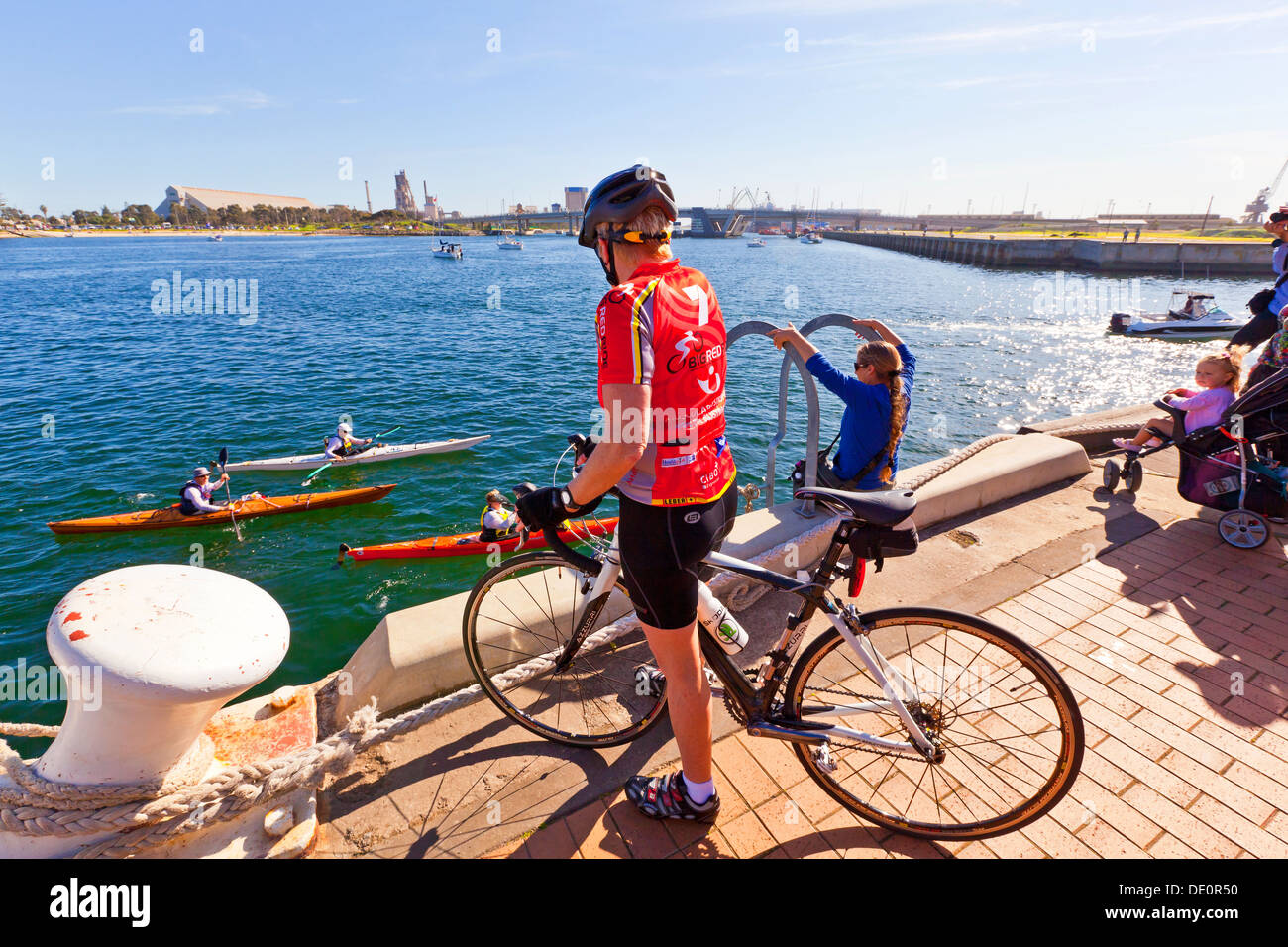 Ein weibliche Radfahrer Uhren Menschen Kanufahrt entlang des Flusses Port in Port Adelaide in South Australia Stockfoto