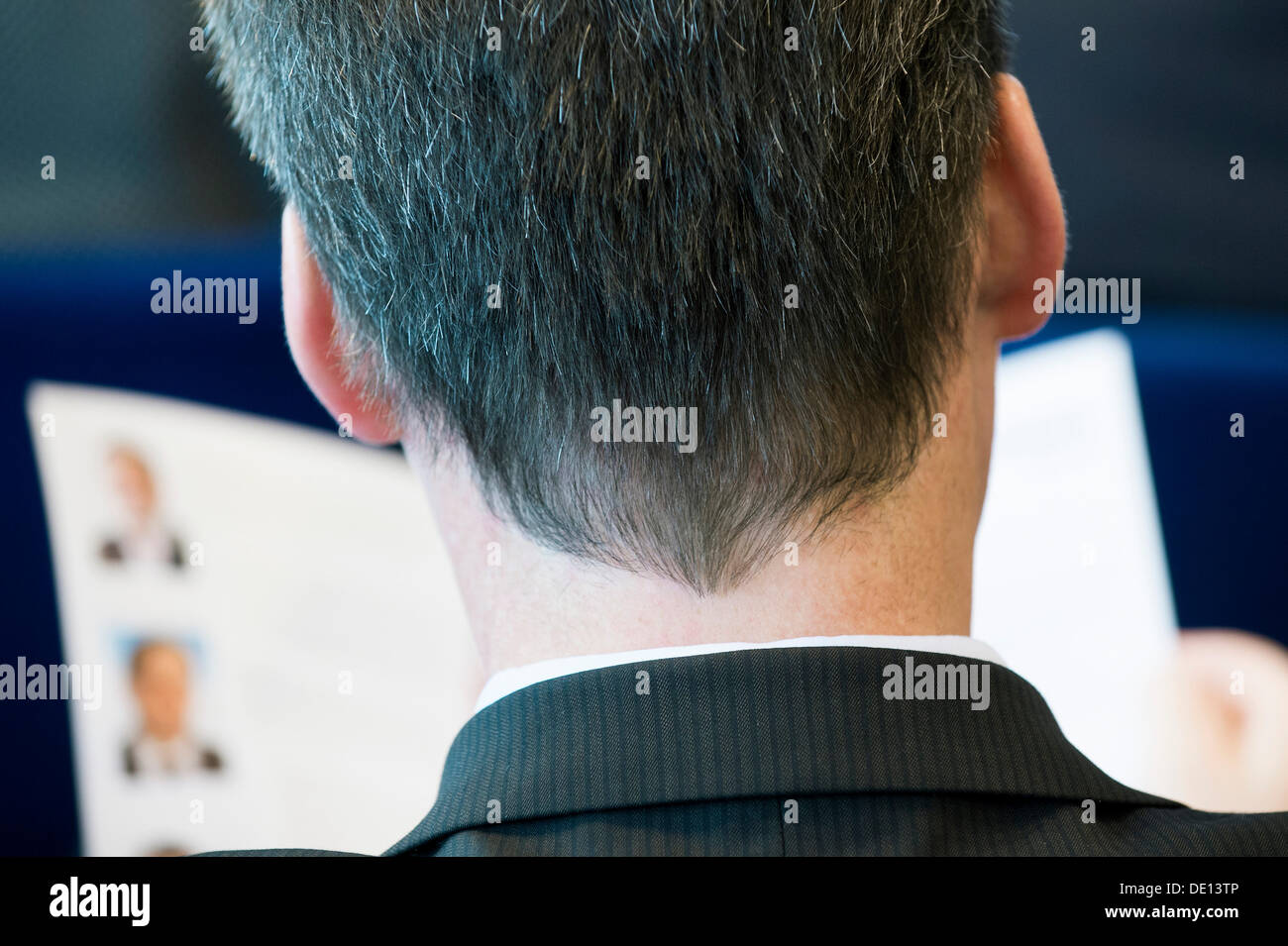 Mann trägt einen Anzug, Konferenzteilnehmer, lesen eine Zeitung, Rückansicht mit der Rückseite des Kopfes Stockfoto