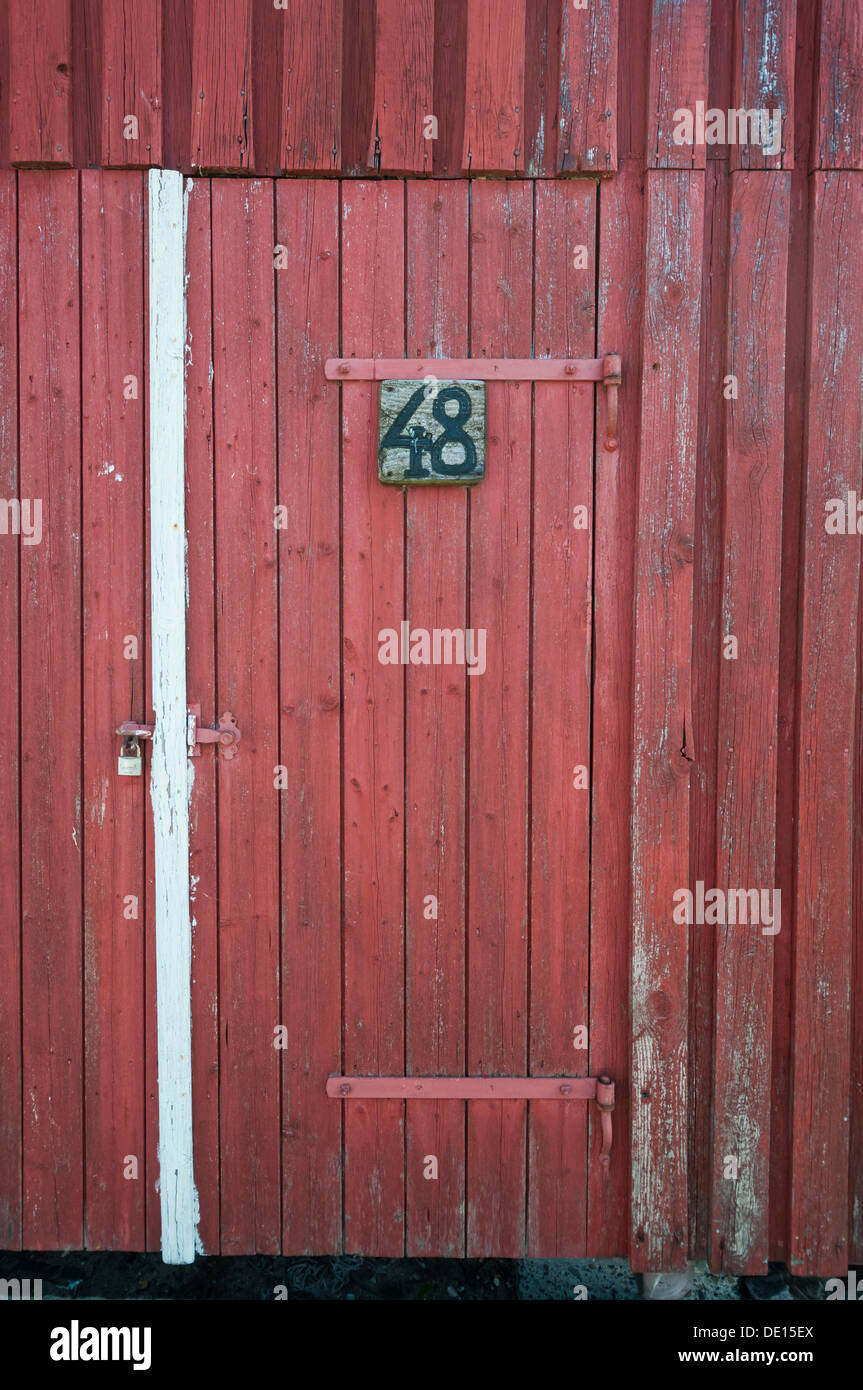 Roter Holztür mit einem Vorhängeschloss und ein Holzschild, Nr. 48 Stockfoto