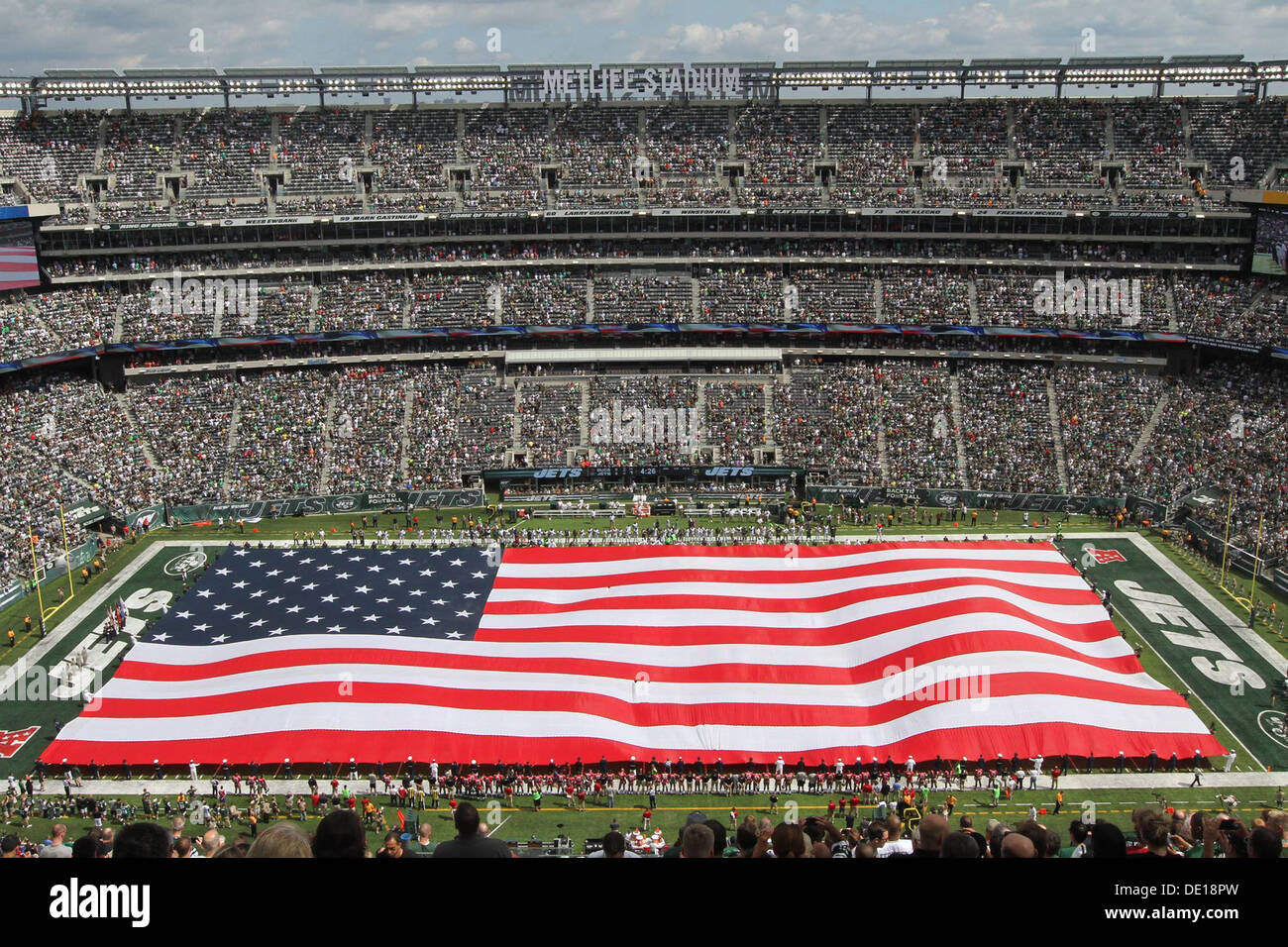 US militärisches Personal vertritt jeder Zweig des Dienstes entfalten die amerikanische Flagge während der pregame Zeremonie MetLife Stadium 8. September 2013 in East Rutherford, NJ. Stockfoto