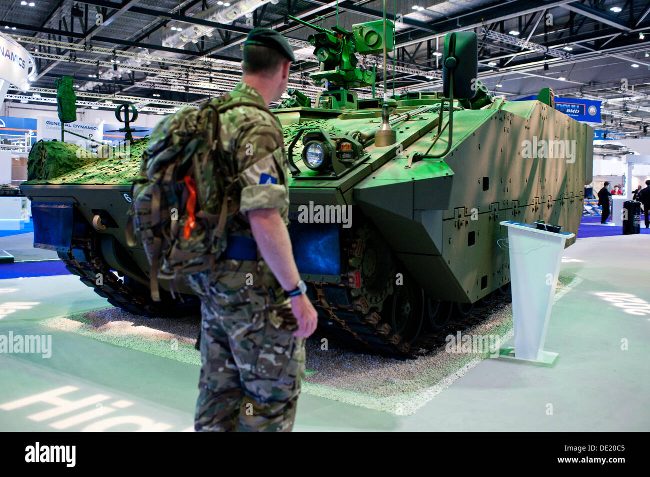 London, UK - 10. September 2013: ein Mann schaut auf ein militärisches Fahrzeug während der Ausgabe 2013 DSEI an Excel London, die weltweit führende Verteidigung & Sicherheitsereignis. Bildnachweis: Piero Cruciatti/Alamy Live-Nachrichten Stockfoto