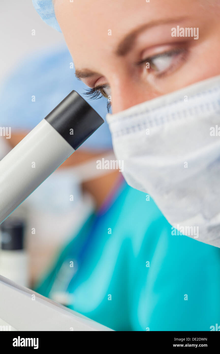 Nahaufnahme eines schönen medizinische oder wissenschaftliche Forscherin oder Arzt im Labor mit ihrem Mikroskop Stockfoto