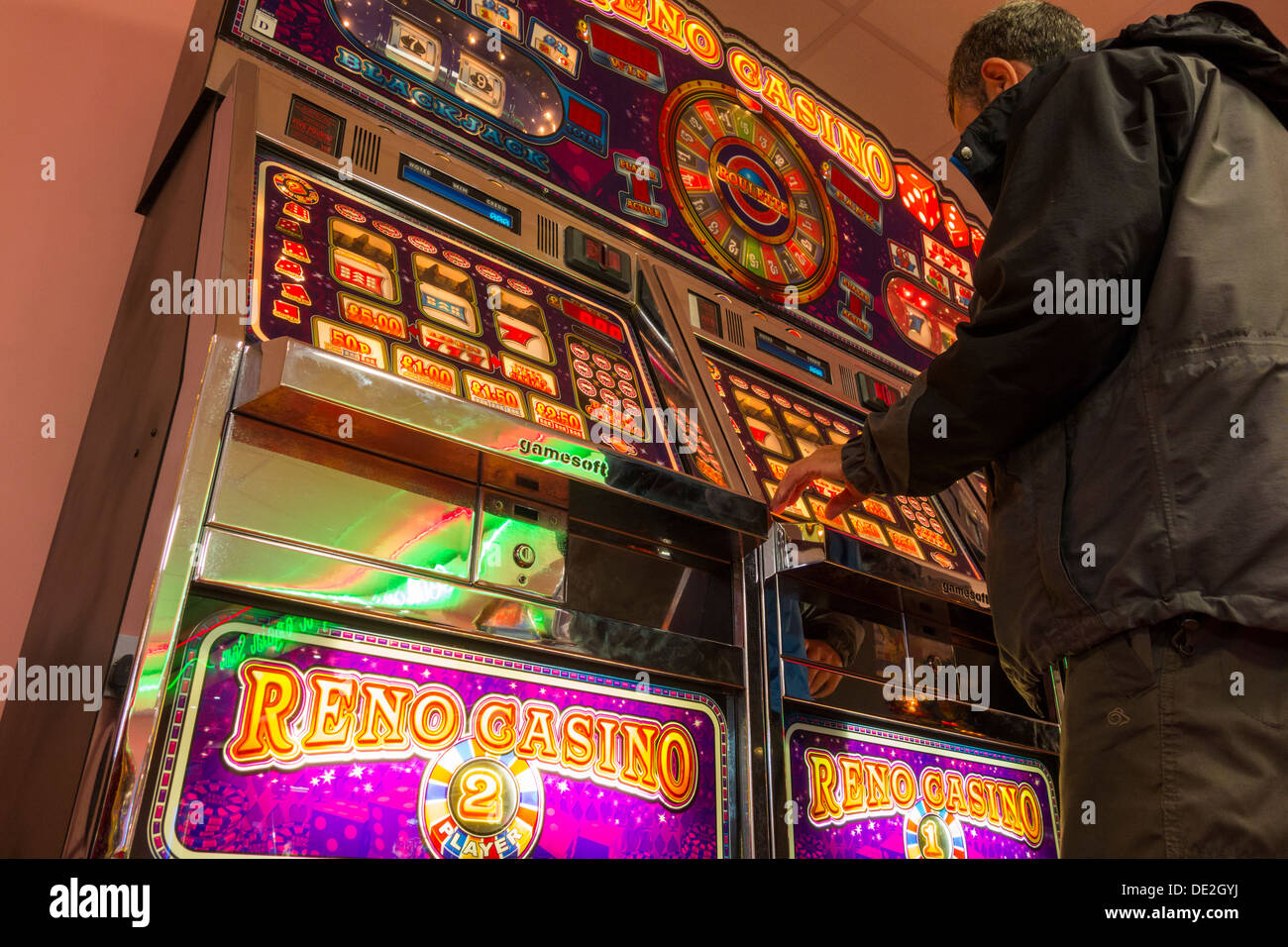 Mann spielt auf Spielautomaten. Stockfoto