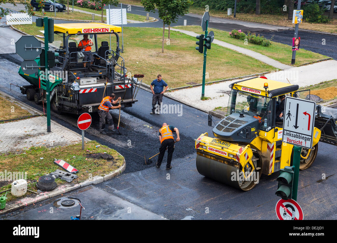 Innerstädtische Straßenbaustelle. Asphaltierte Arbeit an einer großen Straßenkreuzung. Neue Asphaltdecke. Alfred Str., B224 in Essen. Stockfoto