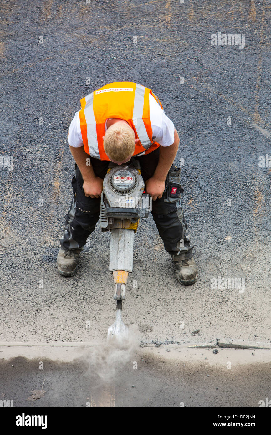 Innerstädtische Straßenbaustelle. Asphaltierte Arbeit an einer großen Straßenkreuzung. Neue Asphaltdecke. Alfred Str., B224 in Essen. Stockfoto