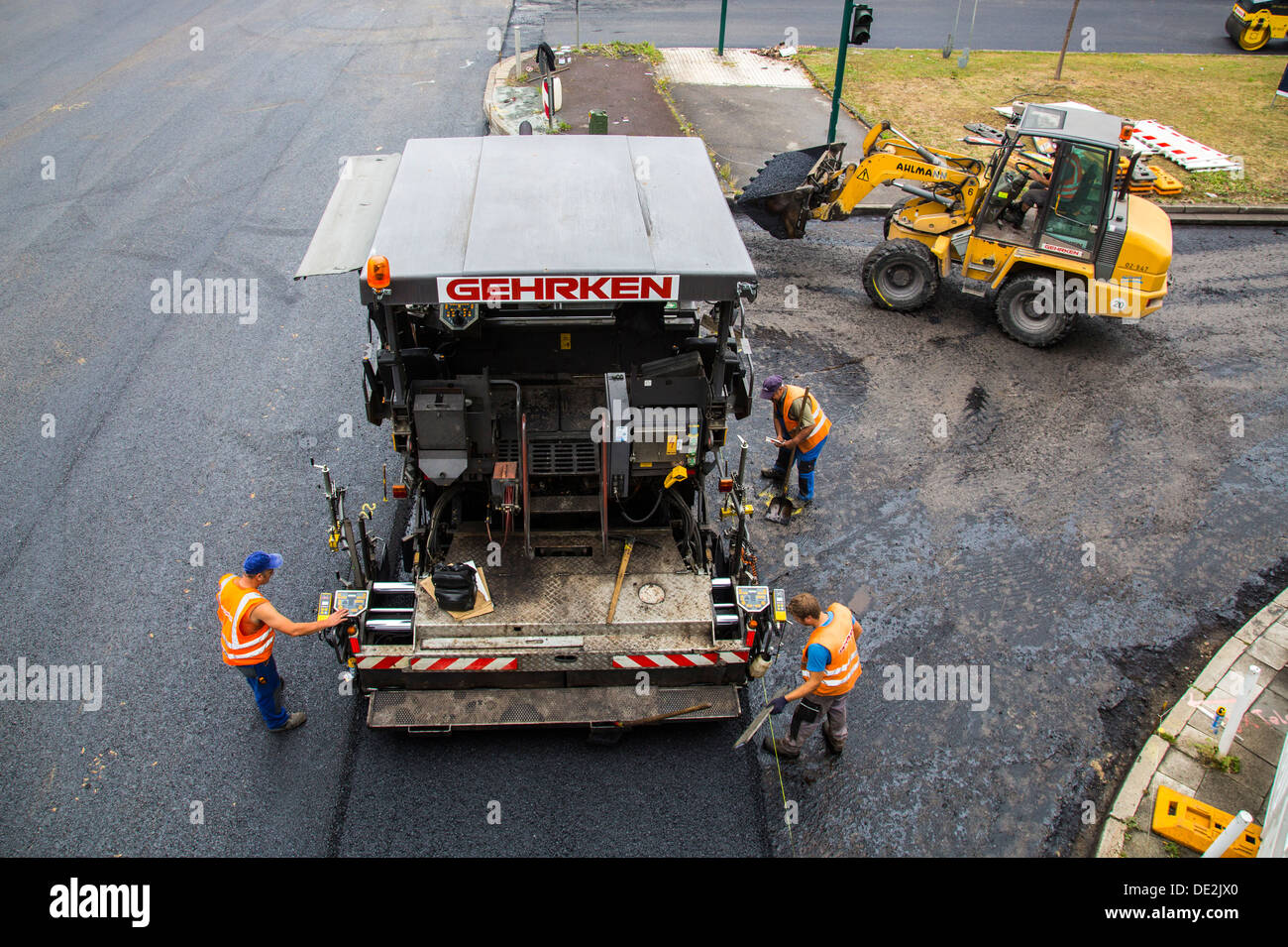 Innerstädtische Straßenbaustelle. Asphaltierte Arbeit an einer großen Straßenkreuzung. Neue Asphaltdecke. Alfred Str., B224 in Essen. Stockfoto